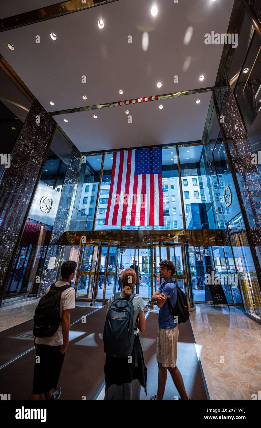 New York, NY, États-Unis. 14 août 2024. Les gens dans le hall de Trump Tower. Les gens vont visiter l'intérieur du gratte-ciel. Un grand drapeau américain est pr Banque D'Images