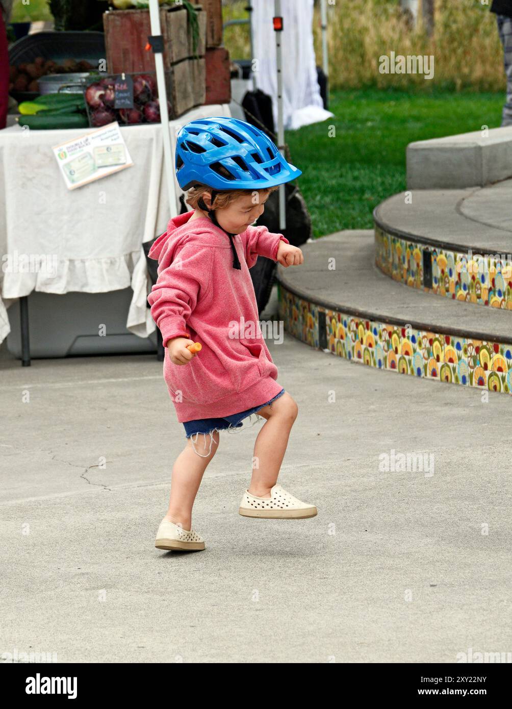 Une jeune fille de quatre ans dansant au son de la musique live dans un marché fermier dans le centre de l'Oregon. Banque D'Images