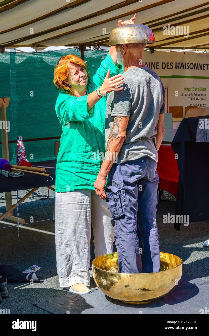 Guérisseur alternatif démontrant un "bol chantant debout" pour la méditation au festival bio - Neuvy-Saint-Sépulchre, Indre-(36), France. Banque D'Images
