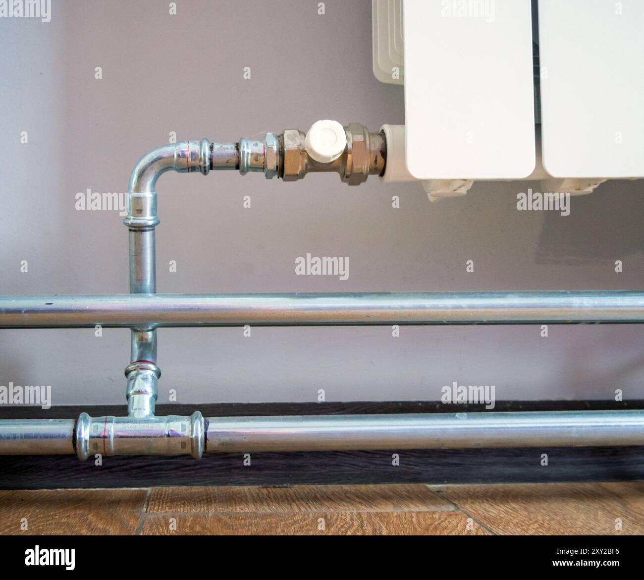 Raccordement d'un radiateur avec raccords de tuyauterie en acier inoxydable Banque D'Images
