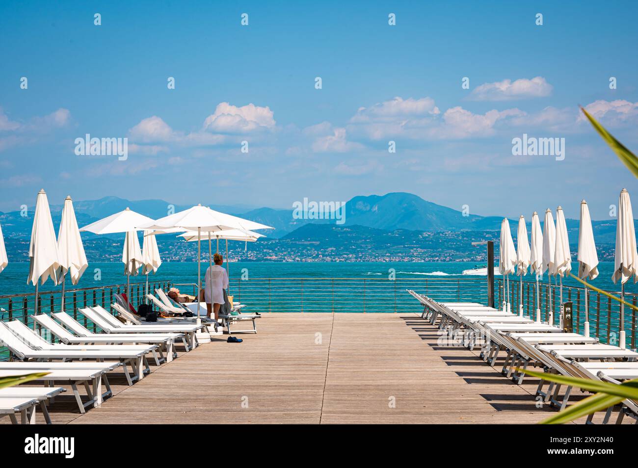 Vue de la station touristique avec parasols et chaises longues à Sirmione sur le lac de Garde, Italie. Banque D'Images