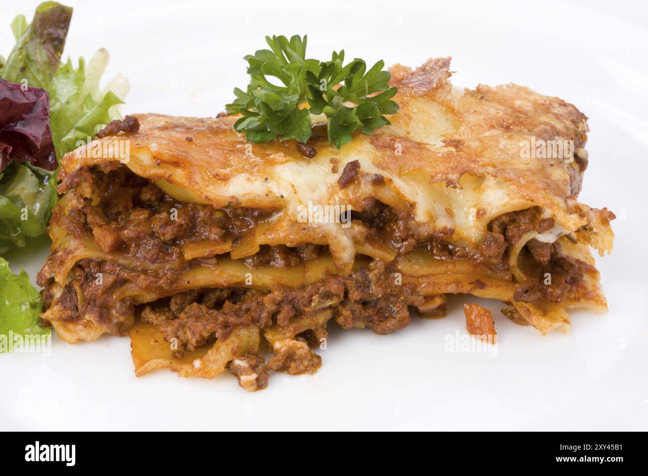 Morceau de lasagne al forno avec un peu de salade Banque D'Images