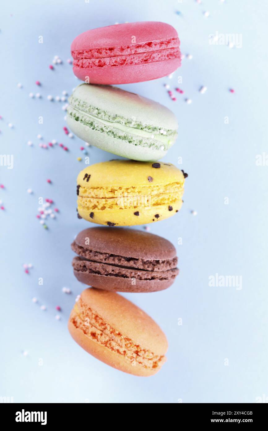 Macarons français colorés sur fond bleu dessert traditioanal en France, vertical Banque D'Images