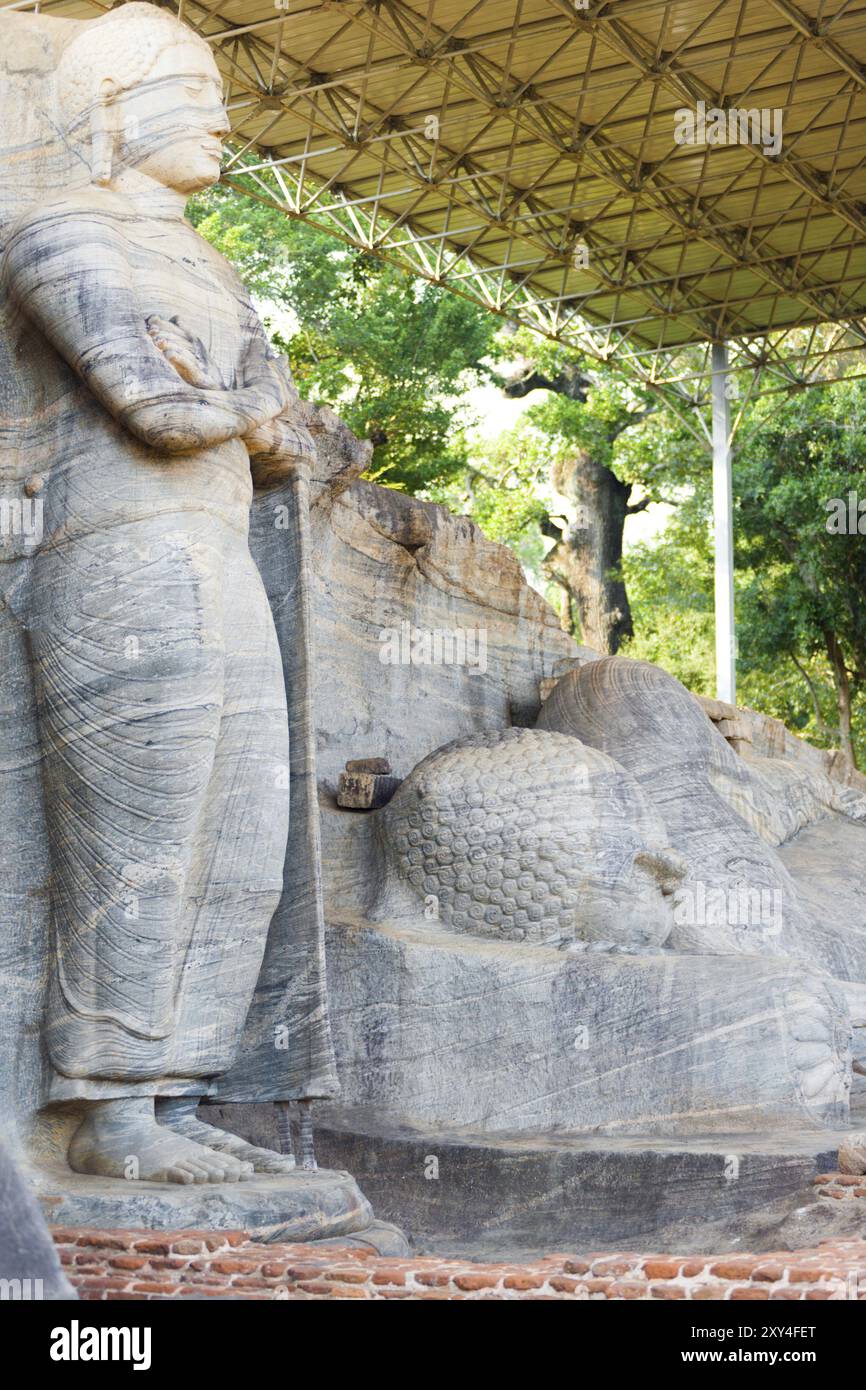 Un toit nouvellement construit couvre et protège les statues monolithiques debout et couchées de Bouddha, le Gal Viharaya, sculpté dans un seul morceau de str Banque D'Images