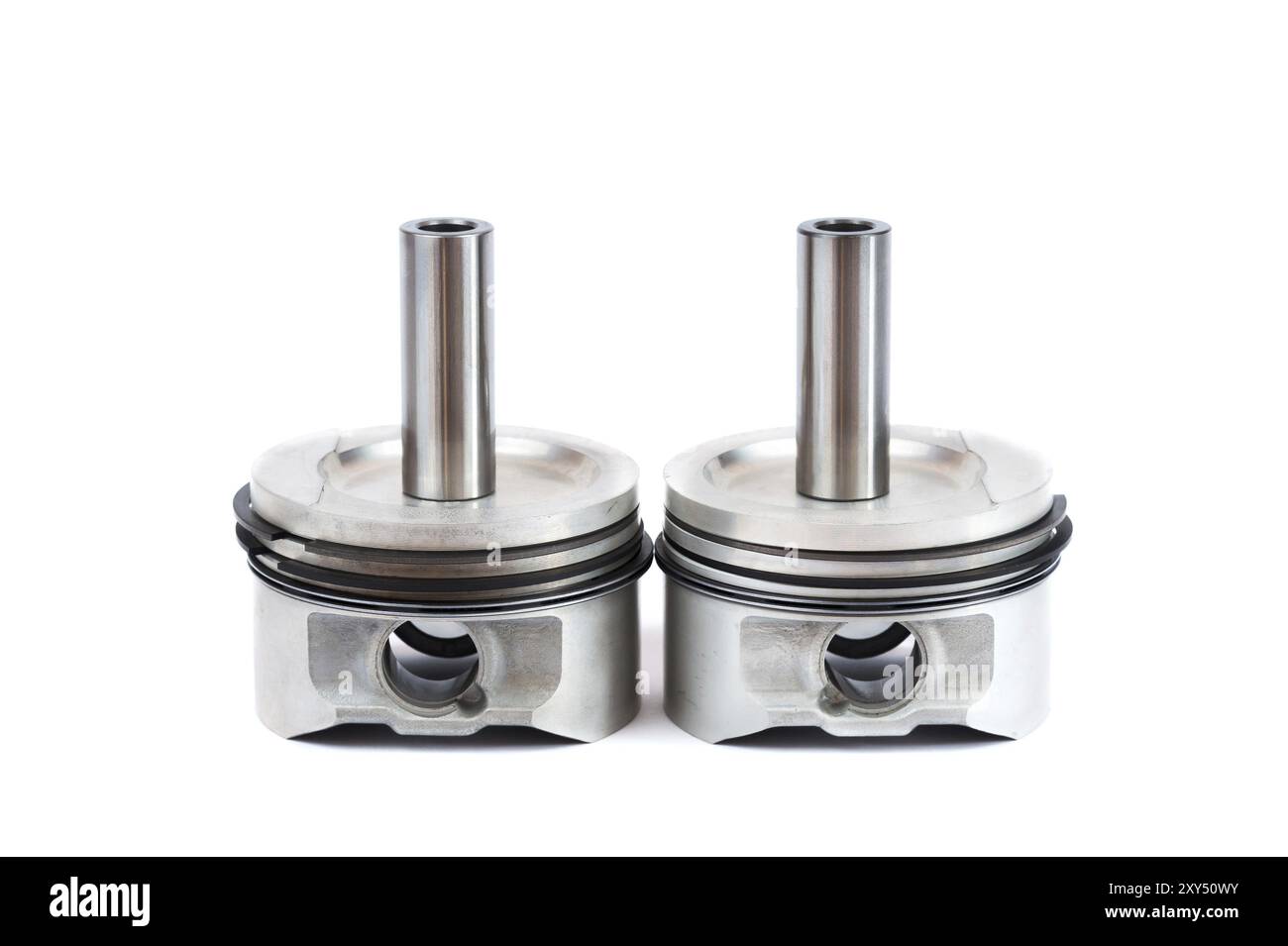 Gros plan des pièces de rechange deux nouveaux pistons avec bielles pour un moteur à essence avec jeux de segments de piston installés sur un fond blanc isolé Banque D'Images
