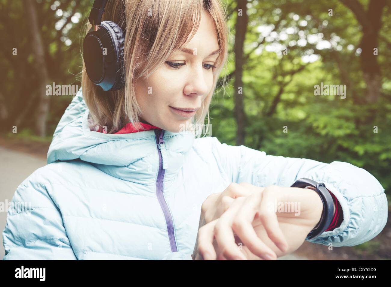 Portrait jeune femme de fitness regardant sa montre intelligente tout en prenant une pause de l'entraînement sportif. Sportive vérifiant le pouls sur la montre intelligente de fitness d Banque D'Images