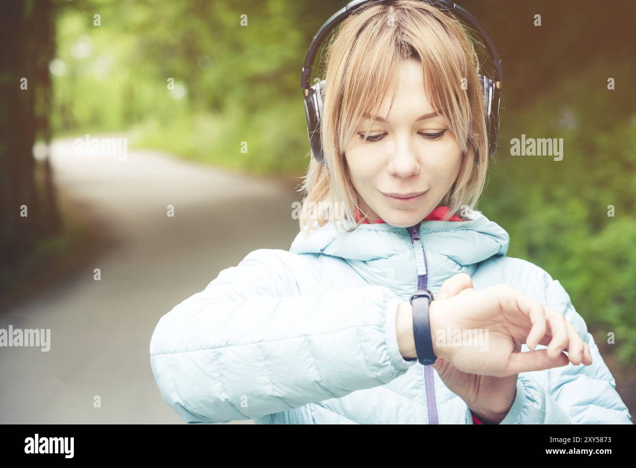 Portrait jeune femme de fitness regardant sa montre intelligente tout en prenant une pause de l'entraînement sportif. Sportive vérifiant le pouls sur la montre intelligente de fitness d Banque D'Images