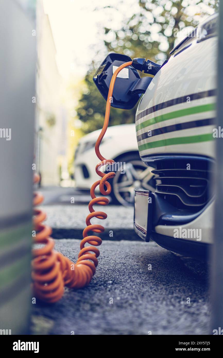 Recharge de voiture électrique avec câble et connecteur de charge menant au point de charge Banque D'Images