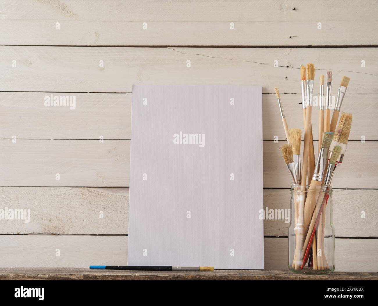 Pinceaux avec une toile sur un fond de bois grange blanche Banque D'Images
