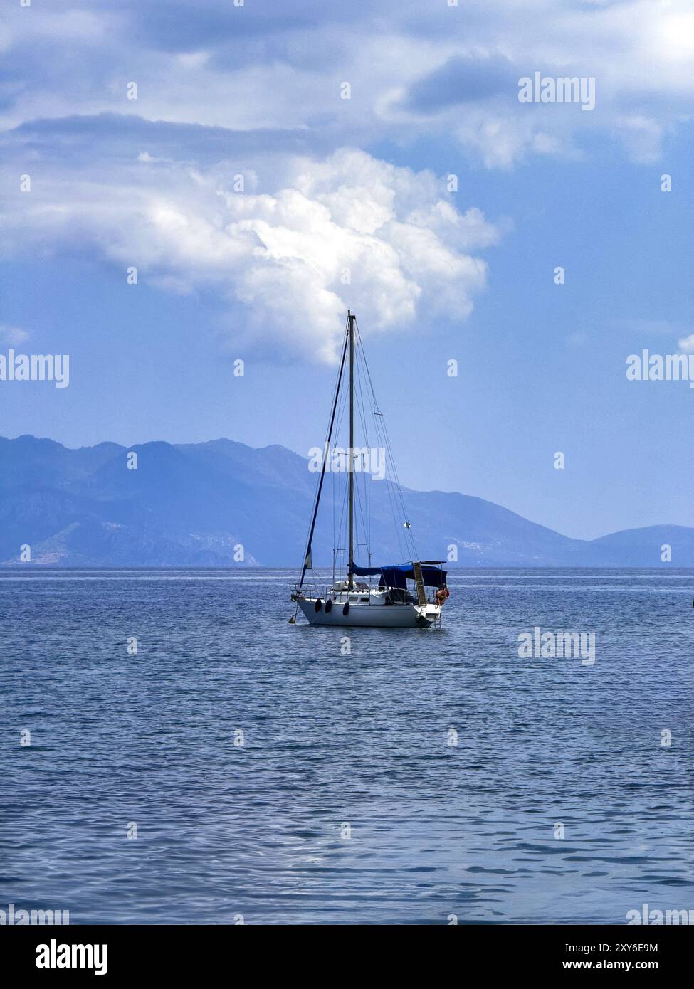 Bateau à voile naviguer sur la mer ondulée, fond de ciel nuageux bleu, Banque D'Images