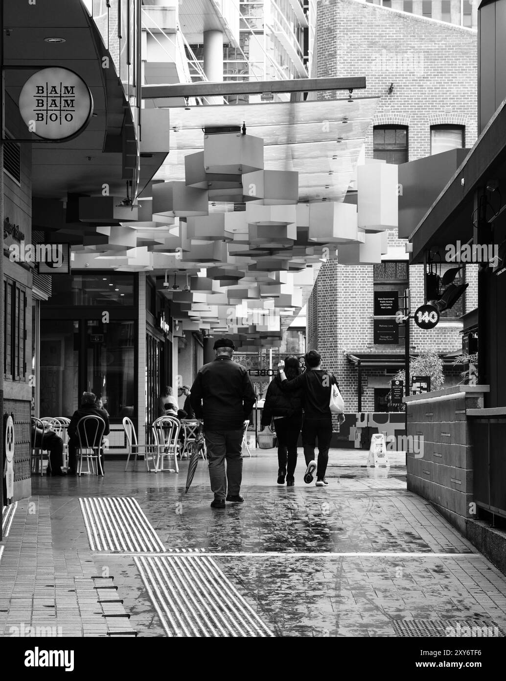 Les gens marchent à travers la ville par un jour humide et pluvieux en hiver à Globe Lane dans le quartier central des affaires de Perth, en Australie occidentale. Banque D'Images