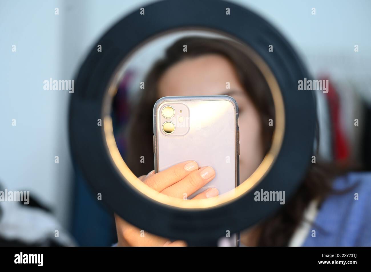 Berlin, Allemagne. 05 juillet 2024. Une femme est assise derrière une lumière annulaire et prend des photos d'elle-même. Crédit : Niklas Graeber/dpa/Alamy Live News Banque D'Images