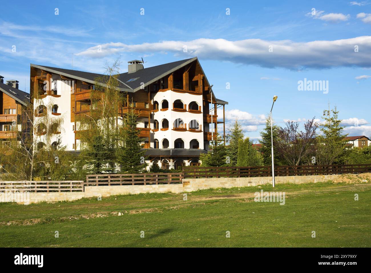 Alpin stile chalet en bois prairie verte et ciel bleu nuageux au printemps, Bansko, Bulgarie, Europe Banque D'Images