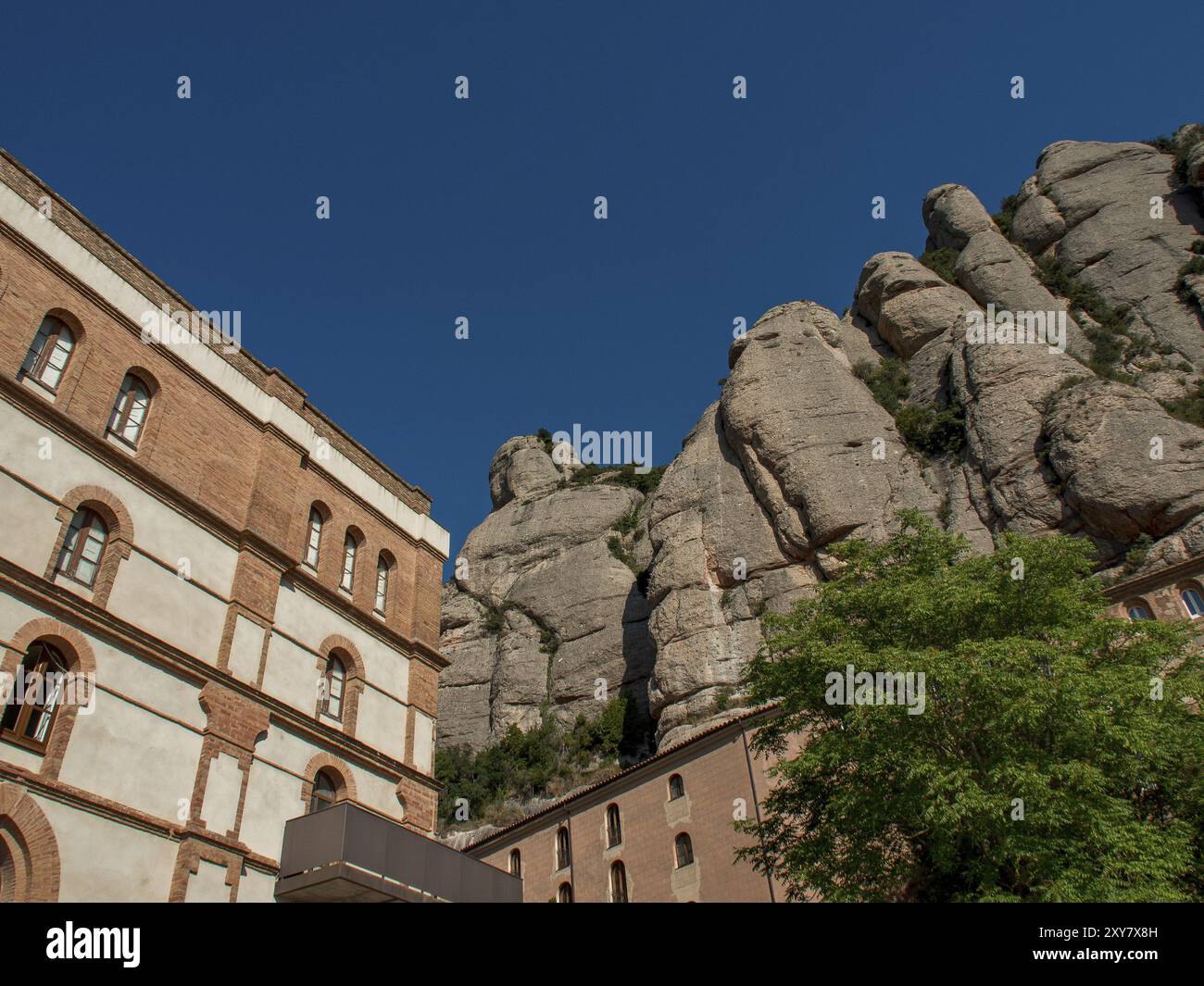 Bâtiments historiques à côté de falaises impressionnantes sous un ciel bleu vif, montserrat, espagne Banque D'Images