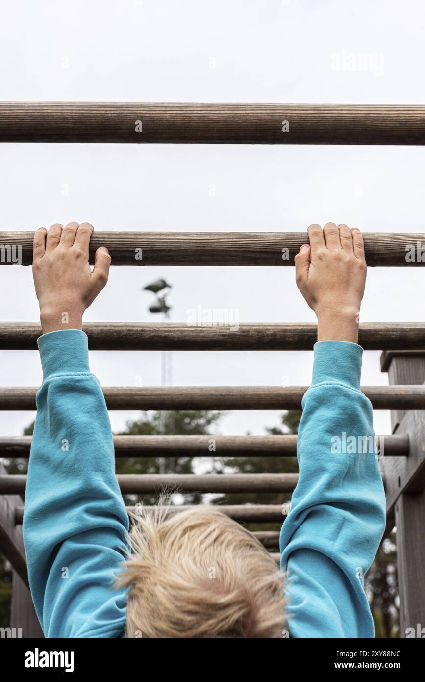 Gothenburg, Suède, 09 mai 2021 : enfant suspendu des mains à un poteau en bois, Europe Banque D'Images