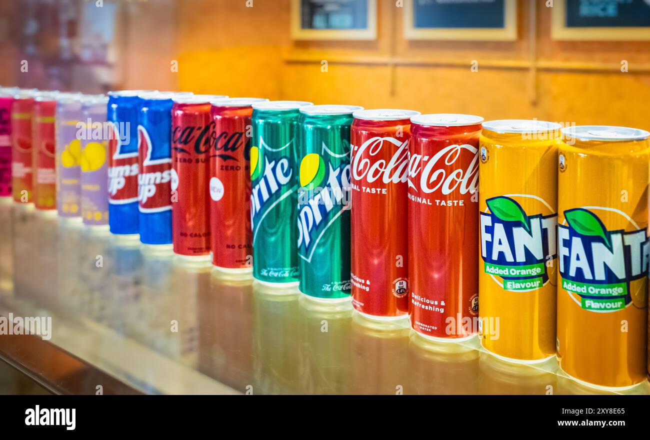 Boîtes de Fanta, Coca-Cola et Sprite sur l'étagère dans un magasin. Canettes de boissons de différentes saveurs en stock. Drin mou non alcoolisé fortement carbonaté Banque D'Images