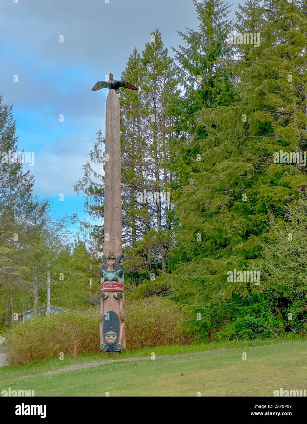 Totem avec aigle se trouve dans Saxman Totem Park, Ketchikan, Alaska.. Les Amérindiens Tlingit l'ont sculptée. L'aigle est au sommet du poteau. Ciel au-dessus. Banque D'Images