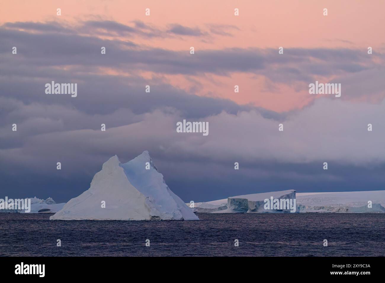 Vue du ciel spectaculaire et des icebergs au coucher du soleil dans le détroit de l'Antarctique, Antarctique. Banque D'Images
