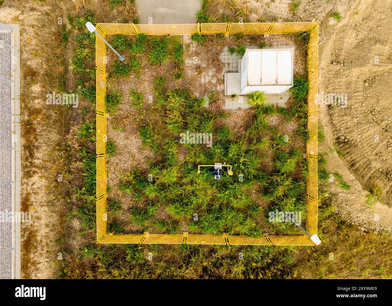 Site abandonné ou sans surveillance d'une grue linéaire télécommandée sur un gazoduc envahi d'herbe Banque D'Images