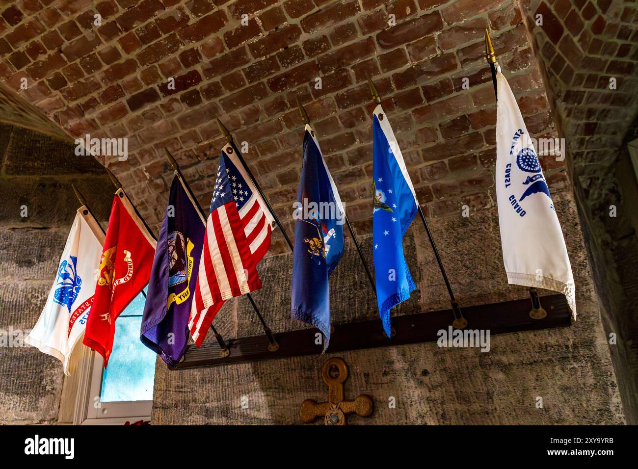 Bronx, NY - US - 24 août 2024 la chapelle de Fort Schuyler présente un plafond voûté en briques et une rangée de drapeaux militaires, y compris le drapeau américain, symbo Banque D'Images