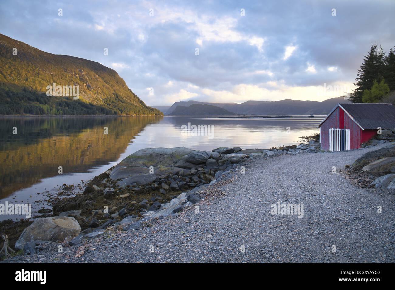 Paysage norvégien. Vue sur un petit port au fjord avec un ciel nuageux derrière la montagne. Nature scandinave Banque D'Images