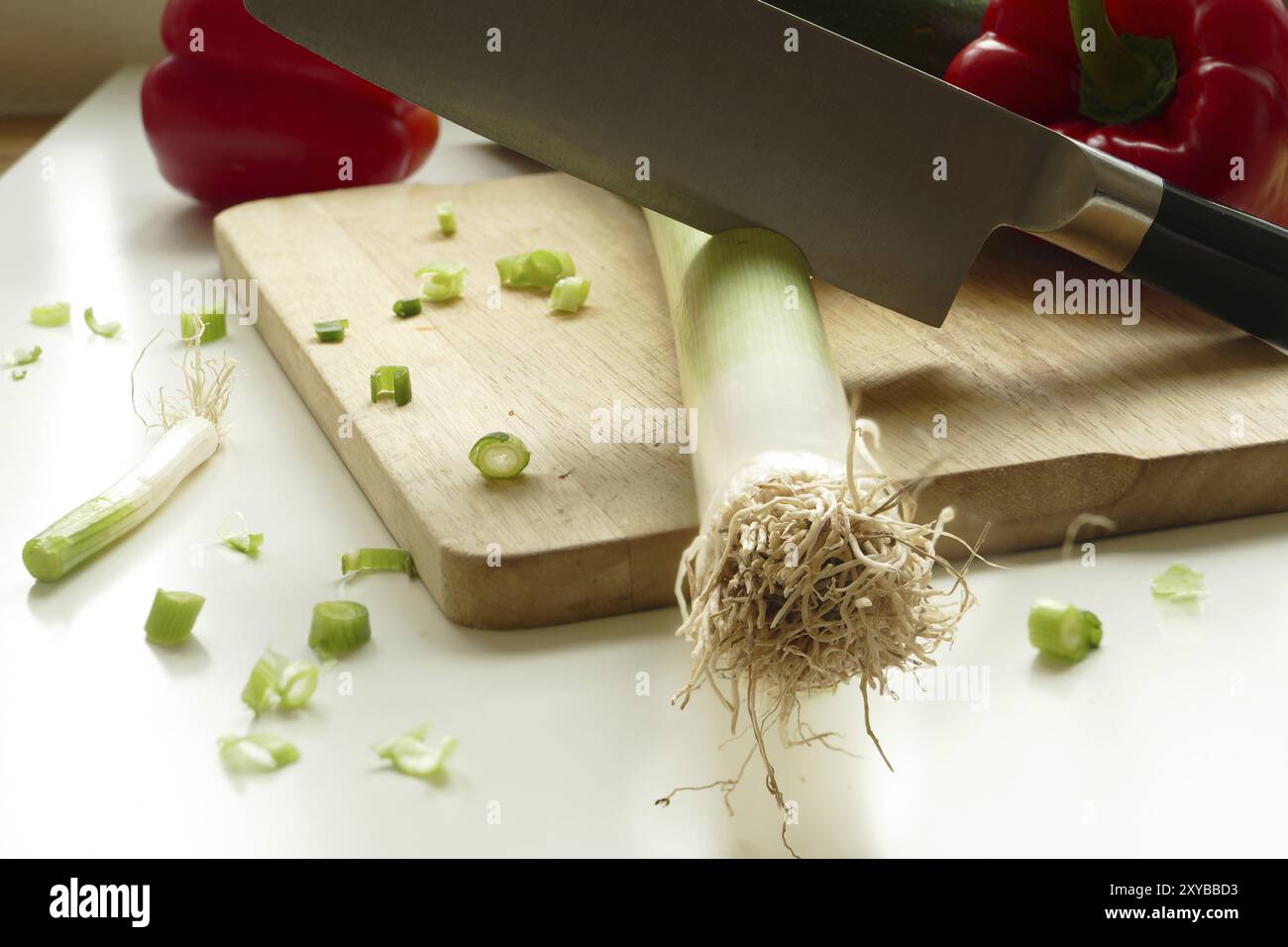 Couper les légumes sur une planche à découper en bois, grand couteau dans le poireau, Papirka en arrière-plan Banque D'Images