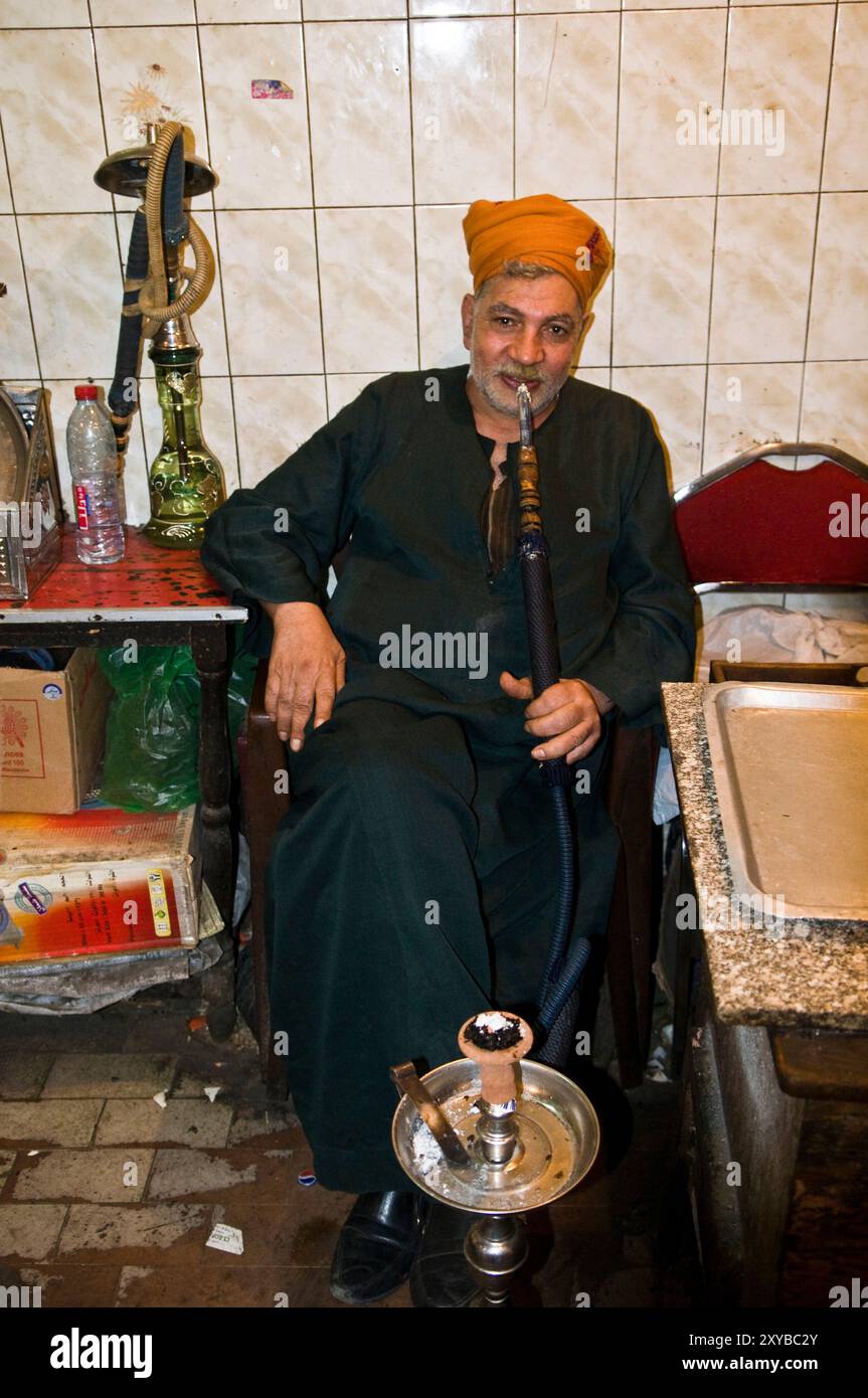 Un égyptien fumant de la chicha dans une petite maison de thé au Caire islamique, le Caire, Egypte. Banque D'Images