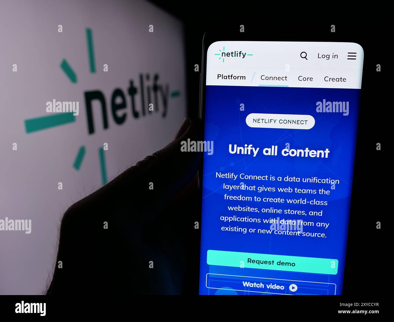 Personne tenant un smartphone avec la page Web de la société de plate-forme de développement Web américaine Netlify Inc devant le logo. Concentrez-vous sur le centre de l'écran du téléphone. Banque D'Images
