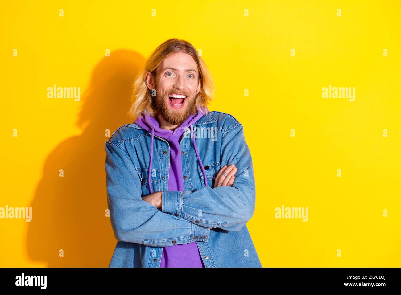 Photo de jeune homme gentil bras pliés espace vide ad porter veste denim isolé sur fond de couleur jaune Banque D'Images