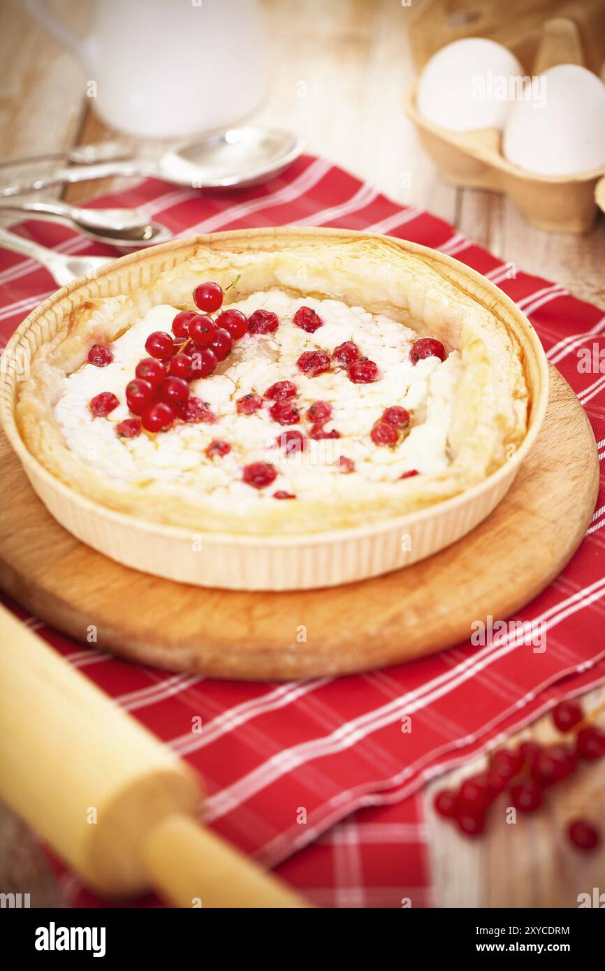 Au-dessus de la délicieuse tarte au fromage maison cuite avec de petites baies rouges sur planche en bois sur table Banque D'Images