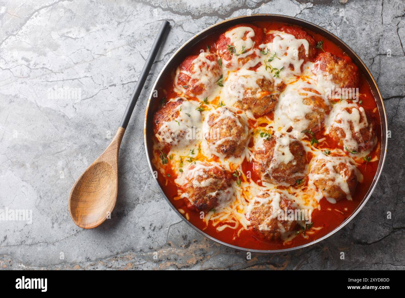 Casserole italienne de boulettes de viande cuites au four dans une sauce tomate épicée avec fromage mozzarella et thym gros plan dans un plat de cuisson sur la table. Vie supérieure horizontale Banque D'Images