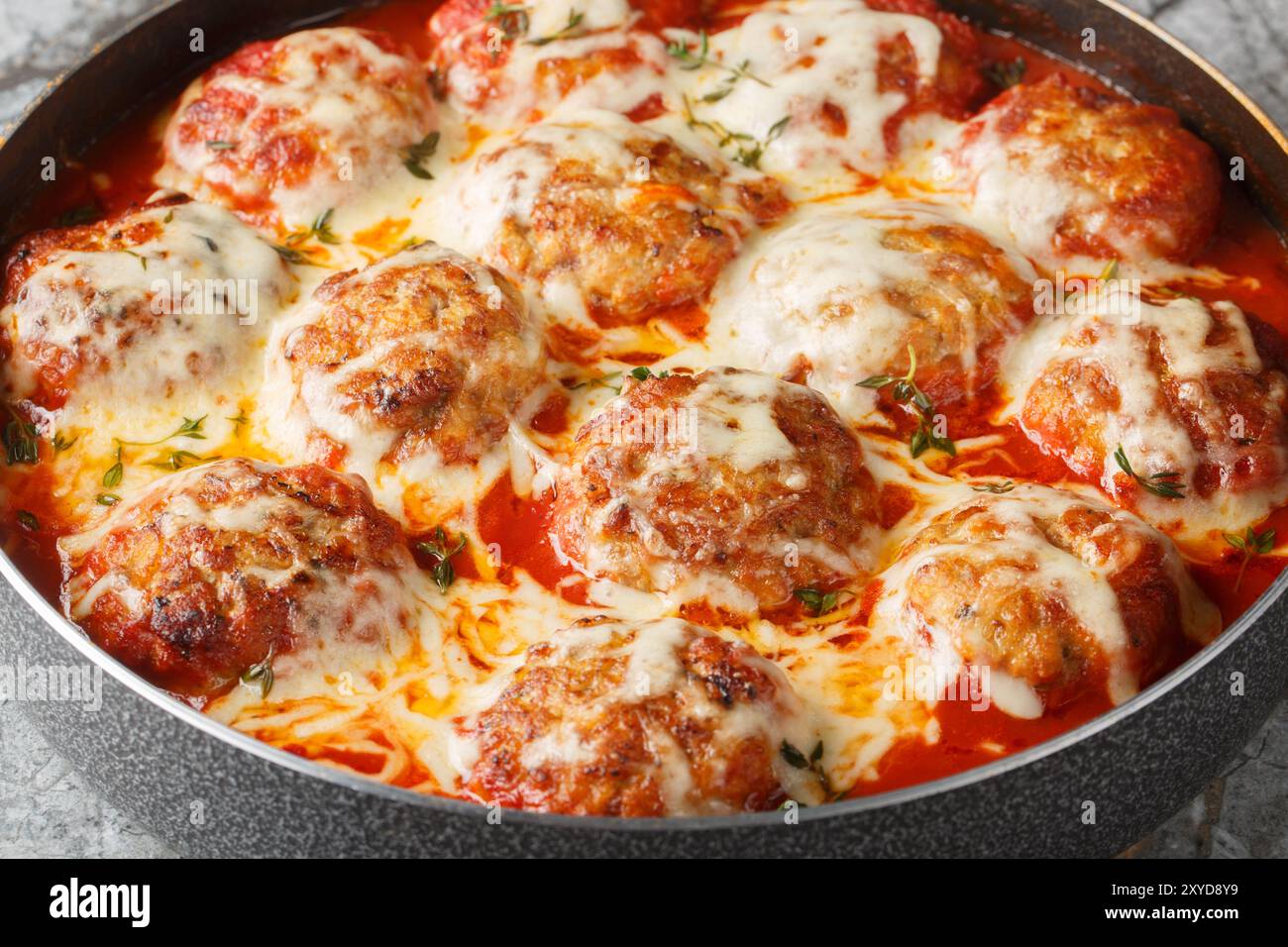 Gratin de boulettes de viande dans une sauce tomate avec du fromage mozzarella et du parmesan gros plan dans une poêle sur la table. Horizontal Banque D'Images