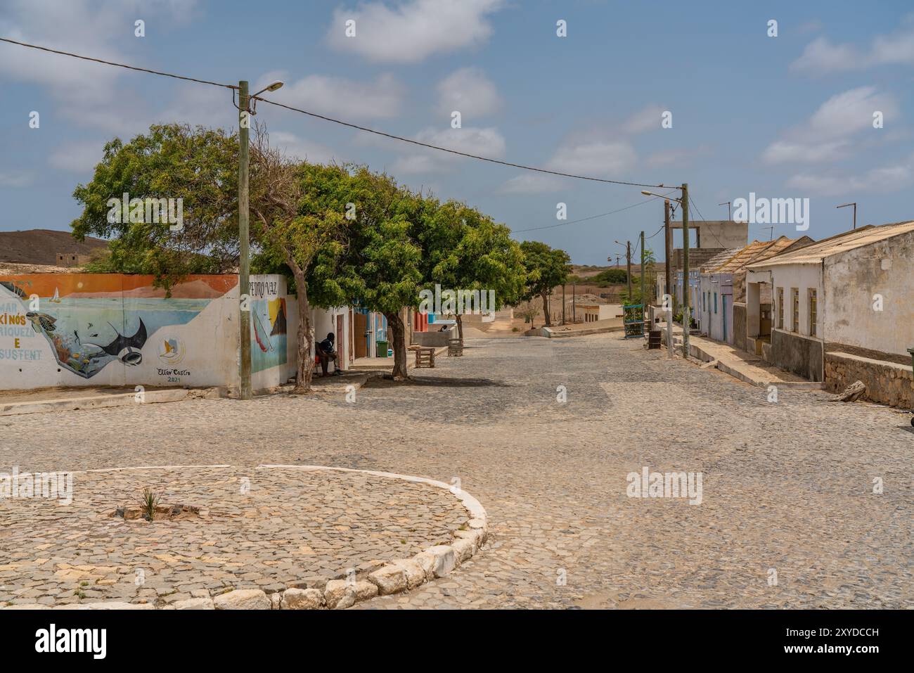 Île de Maio, Cap-vert - 25 juin 2024 : vue sur la rue du village de Pedro vas avec un homme assis sous un arbre sur l'île de Maio Banque D'Images