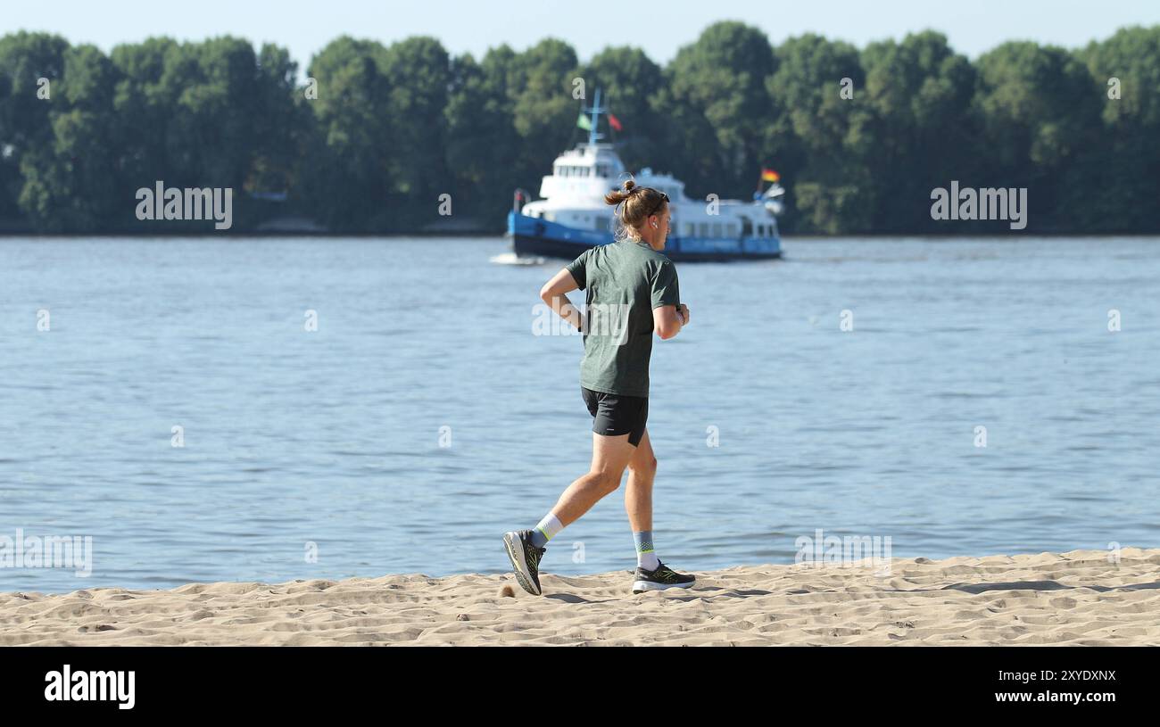 Ein Mann joggt BEI Temperaturen über 30 Grad am Elbstrand in Övelgönne entlang. Altona Hamburg *** Un homme fait du jogging le long de la plage de l'Elbe à Övelgönne à des températures supérieures à 30 degrés Altona Hamburg Banque D'Images