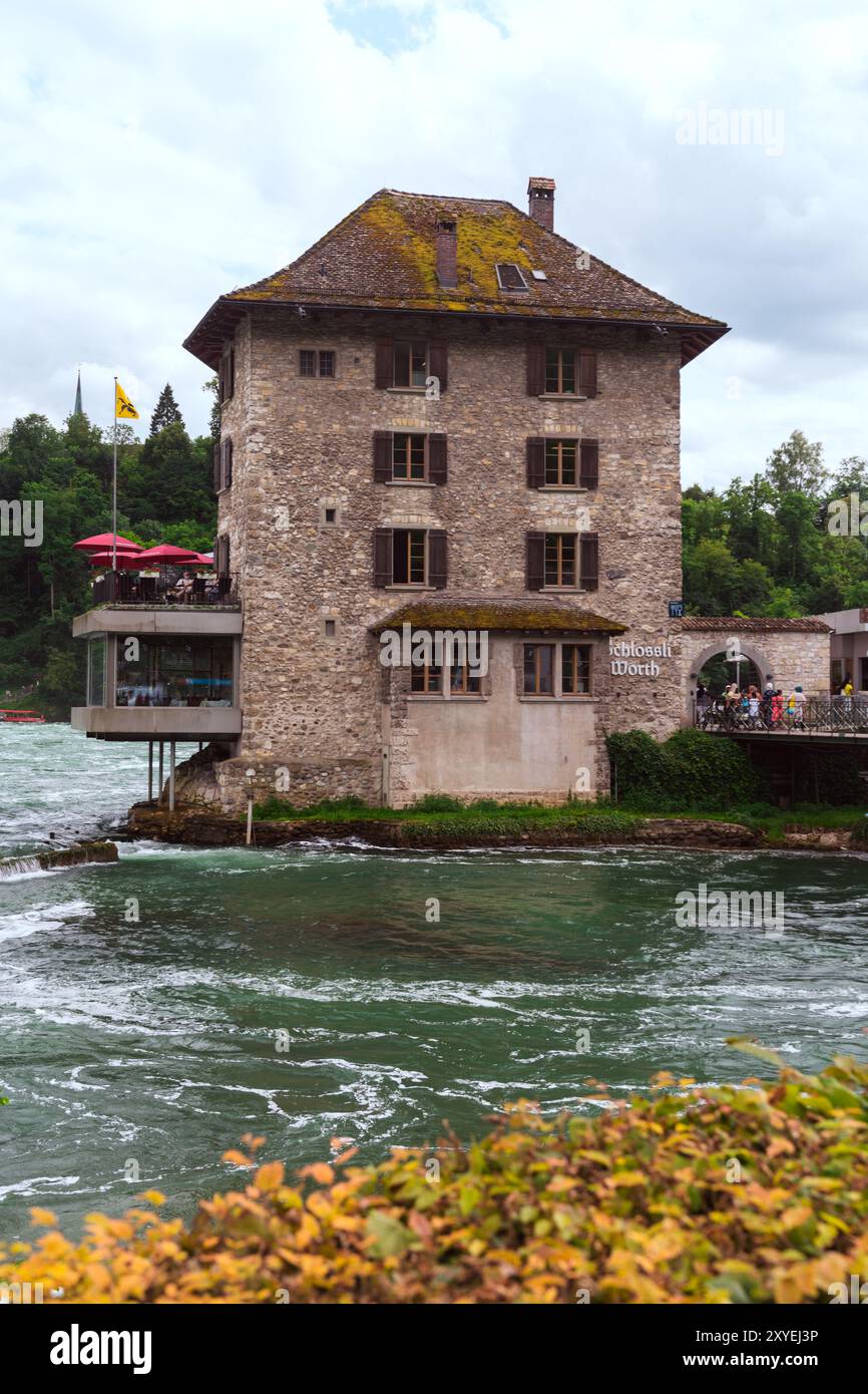 Schaffhausen, Suisse - 17 juillet 2024 : Schloss Worth (château d'eau) aux chutes du Rhin est un château et un restaurant ouvert aux touristes Banque D'Images