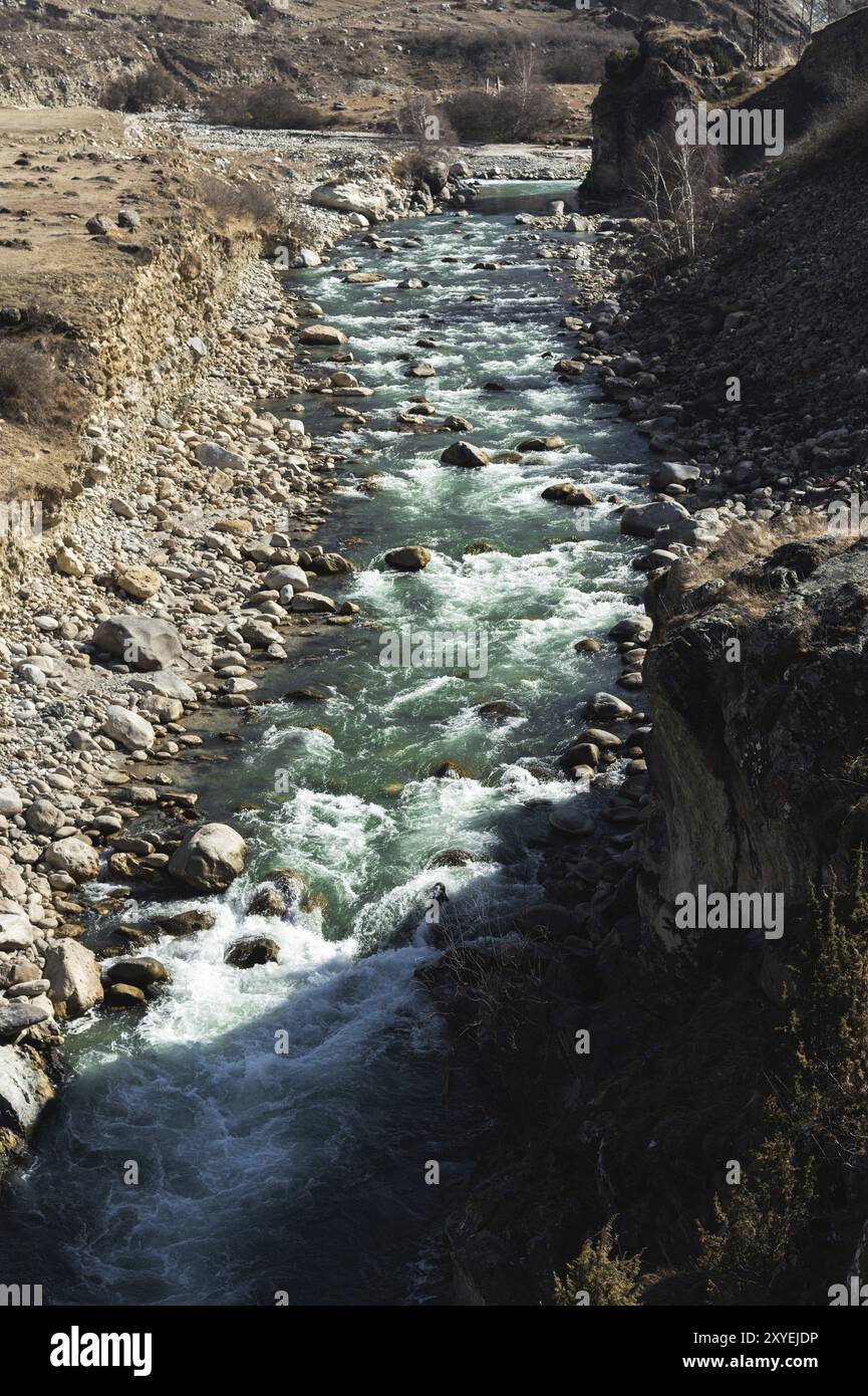 Rivière de montagne orageuse avec des éclaboussures de pierres et de la mousse avec de l'eau potable claire de couleur émeraude. Le concept de sources naturelles de boisson de montagne wa Banque D'Images