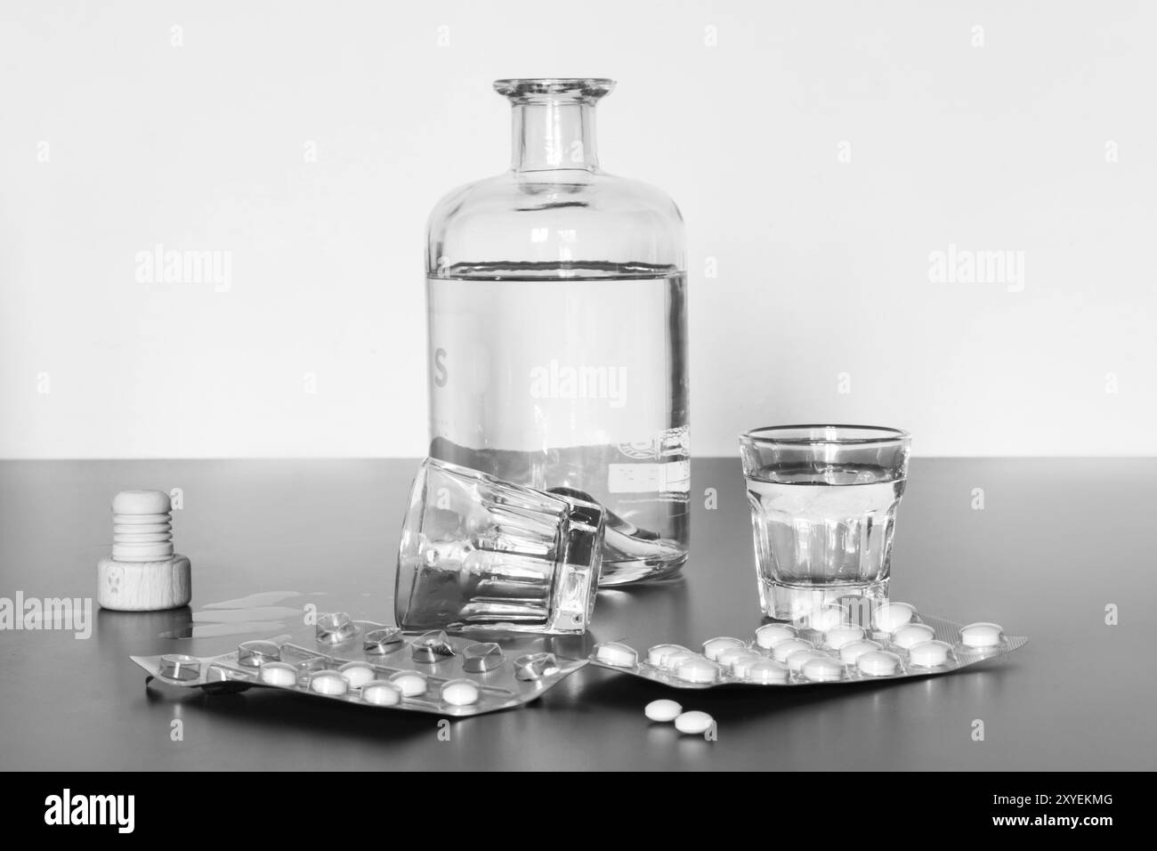Pilules et alcool sur une table grise. Concept de toxicomanie Banque D'Images