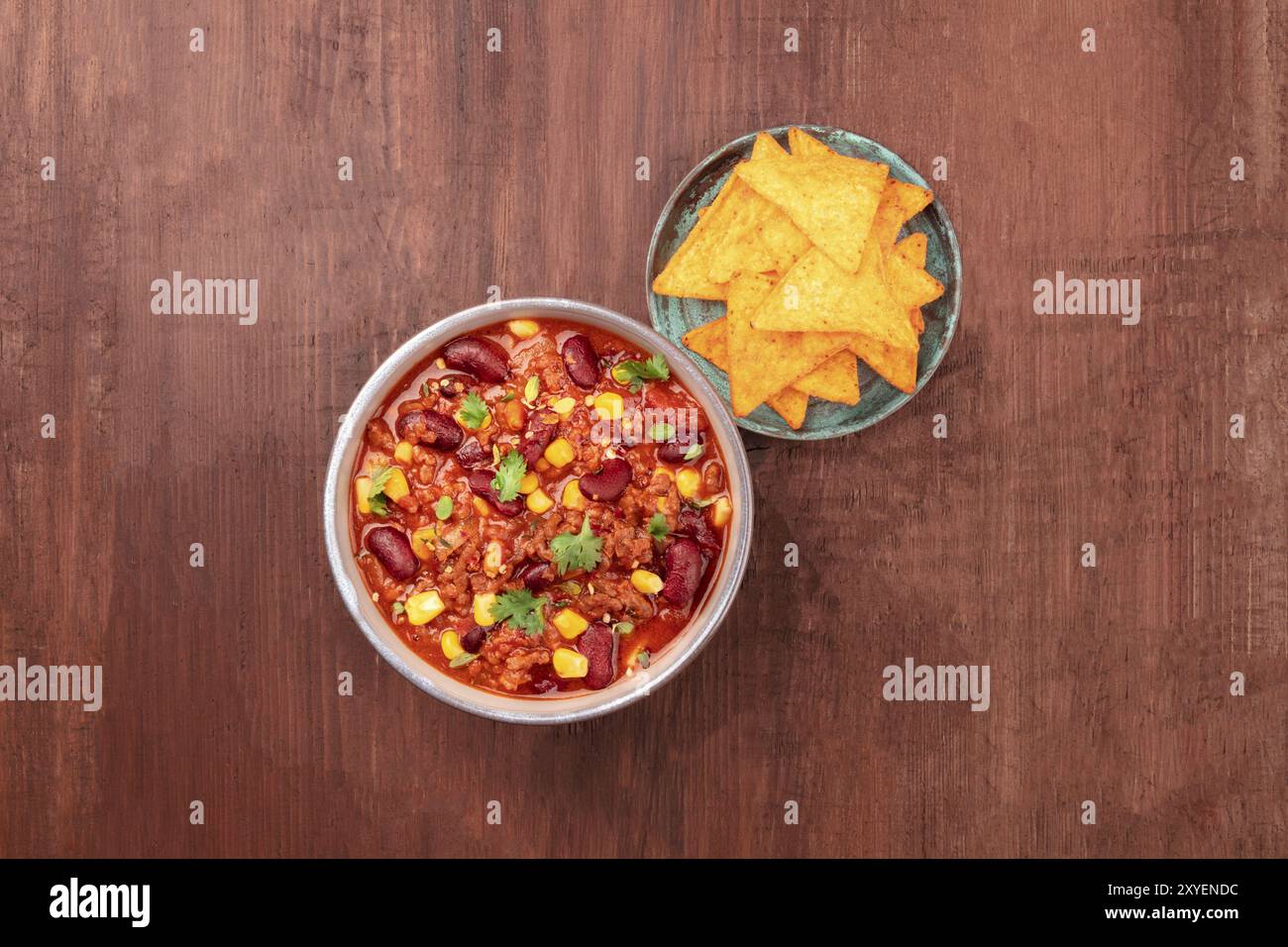 Une photo prise à la verticale du chili con carne, un plat traditionnel mexicain avec les haricots rouges, feuilles de coriandre, la viande hachée, et le piment, avec des nachos, tortill Banque D'Images