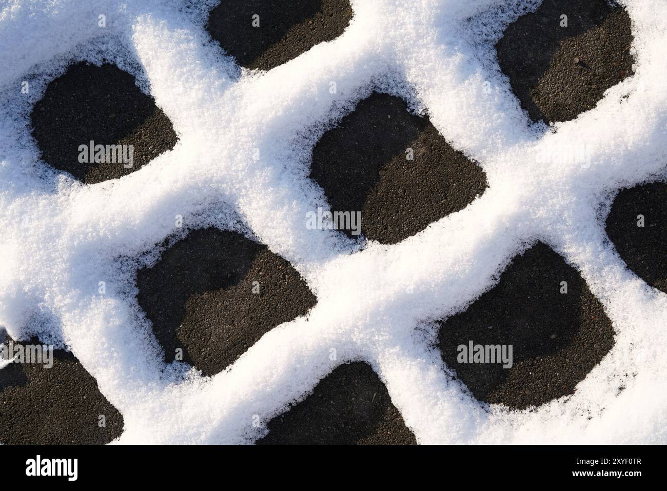 Neige sur les joints de pavés sur un chemin piétonnier en hiver Banque D'Images