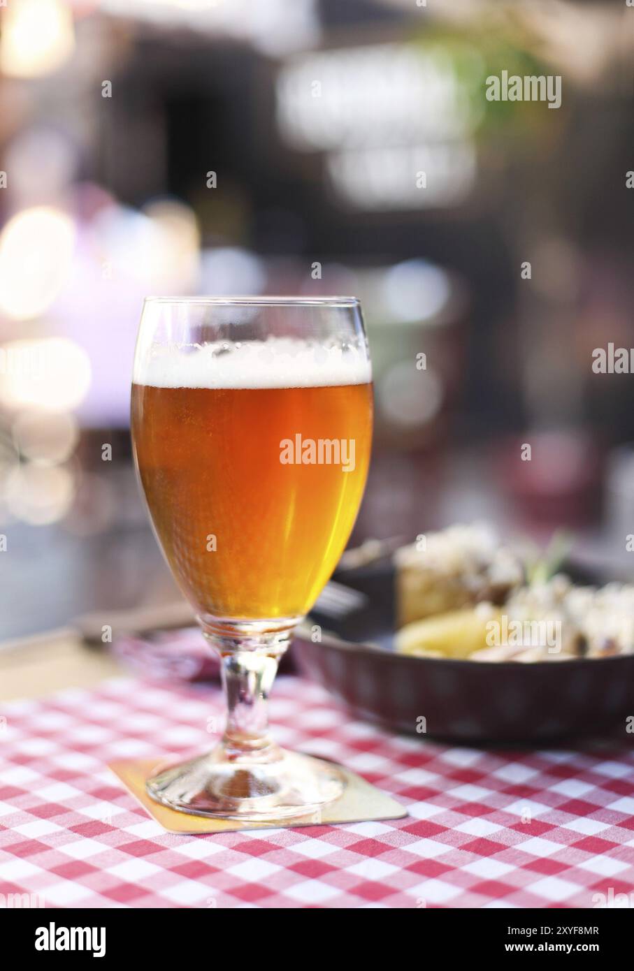 Un verre de bière légère avec salade au pub Banque D'Images