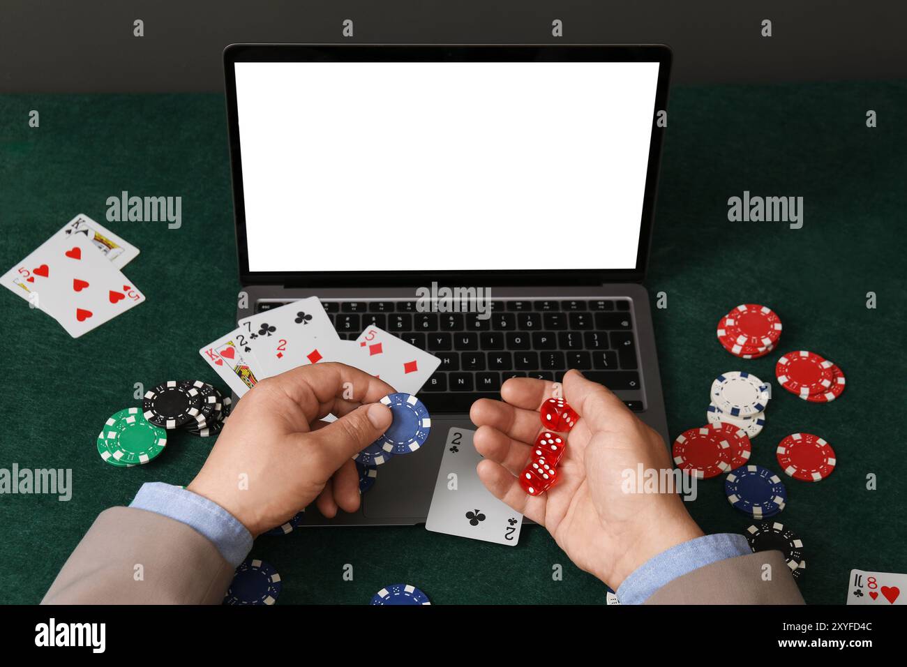 Poker en ligne. Homme tenant des jetons et des dés à la table verte avec ordinateur portable, gros plan Banque D'Images
