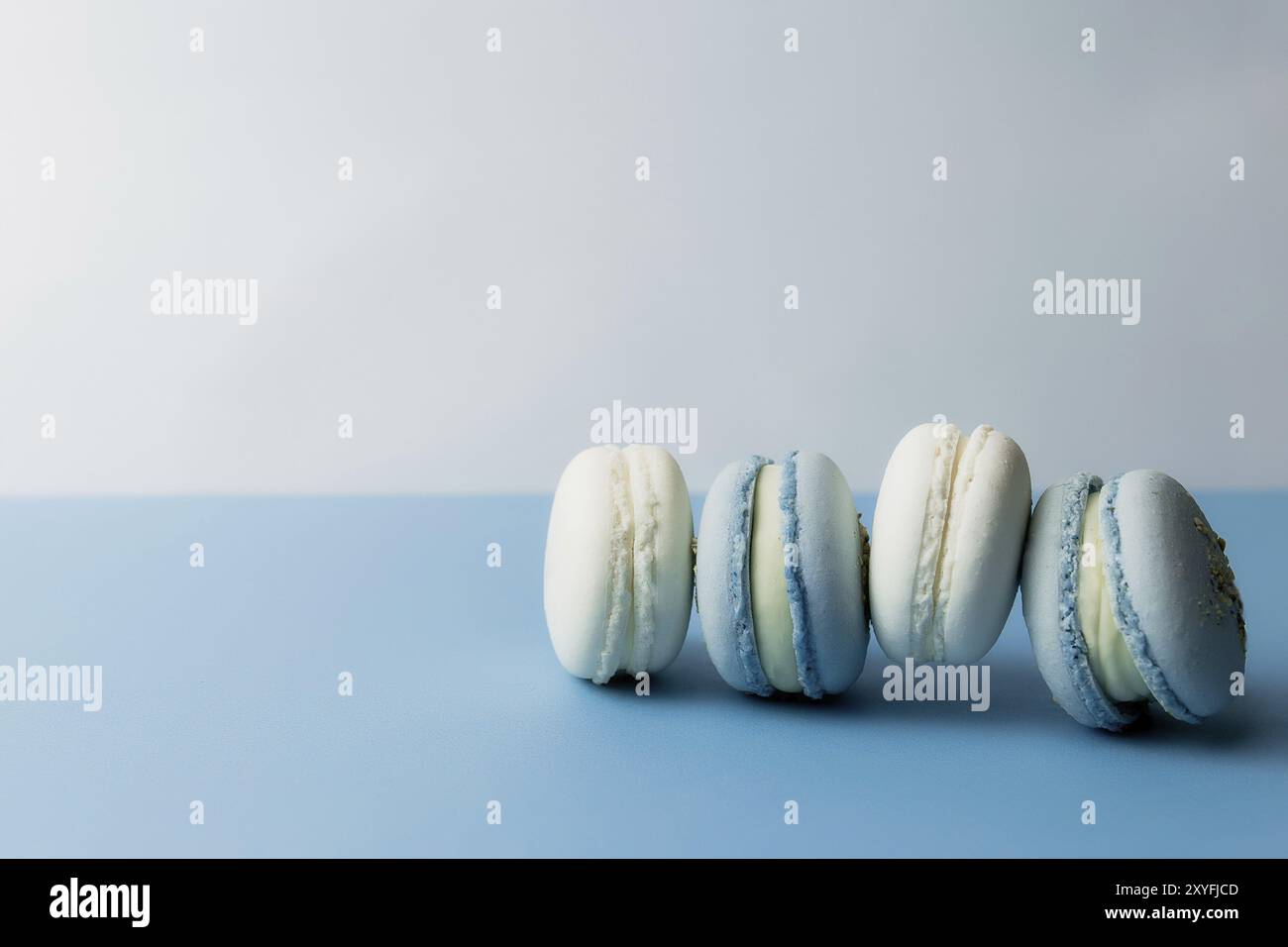 Macarons blancs et bleus sur la table, macarons sur fond bleu. Banque D'Images