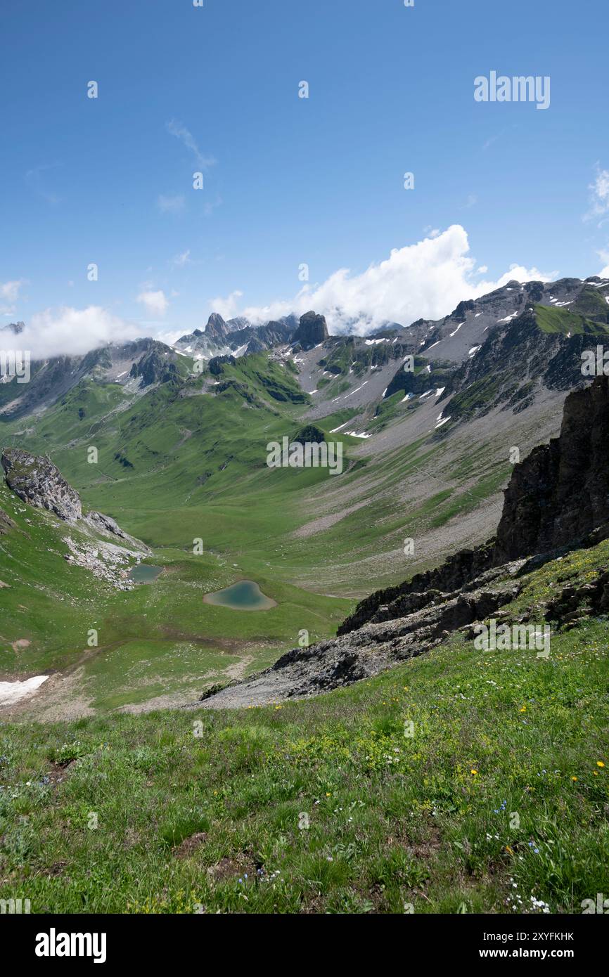 Paysage montagneux vertical de Pierra Menta à Beaufort, Savoie, France, présentant une herbe verte luxuriante couvrant des sommets accidentés pendant l'été Banque D'Images