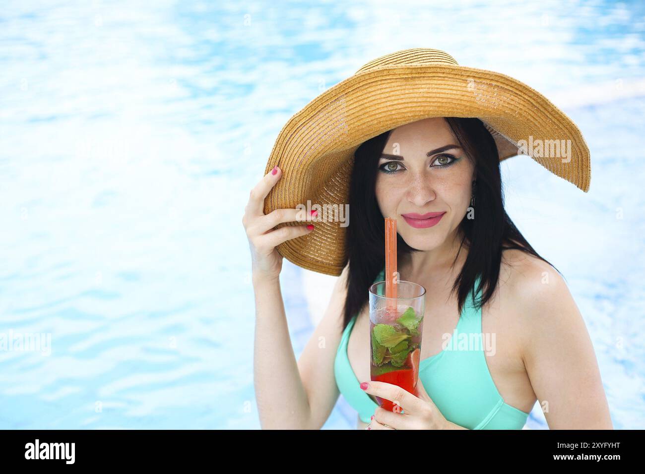 Beauté féminine réelle profitant de ses vacances d'été à la piscine avec un cocktail d'alcool Banque D'Images