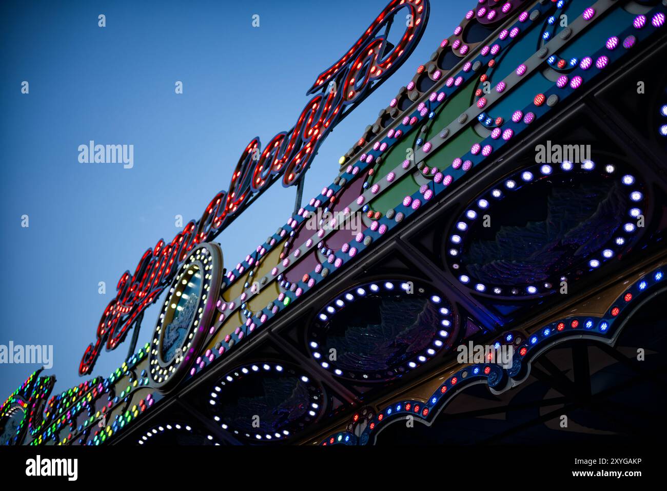 Lumières de carnaval Arlington Virginie // ARLINGTON, Virginie — des lumières colorées illuminent une promenade de carnaval au crépuscule pendant la foire du comté d'Arlington à Arlington, Virginie. L'événement communautaire annuel présente des manèges, des jeux, des vendeurs de nourriture et des expositions. Fondée en 1977, la foire du comté d'Arlington est l'un des plus grands événements à entrée gratuite de Virginie du Nord, attirant généralement des milliers de visiteurs chaque année au centre communautaire Thomas Jefferson. Banque D'Images