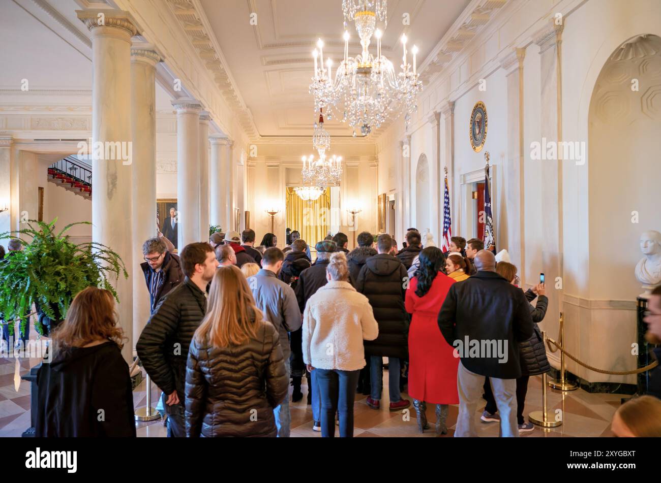 Visite publique de la Maison Blanche Cross Hall Washington DC // WASHINGTON DC — les visiteurs explorent le Cross Hall menant au hall d'entrée principal de la Maison Blanche lors d'une visite autoguidée. Cet accès public au manoir exécutif de l'Amérique permet aux citoyens de voir les intérieurs historiques de la résidence présidentielle. Les participants à la visite observent les détails architecturaux et historiques de l'espace d'entrée formel. Banque D'Images