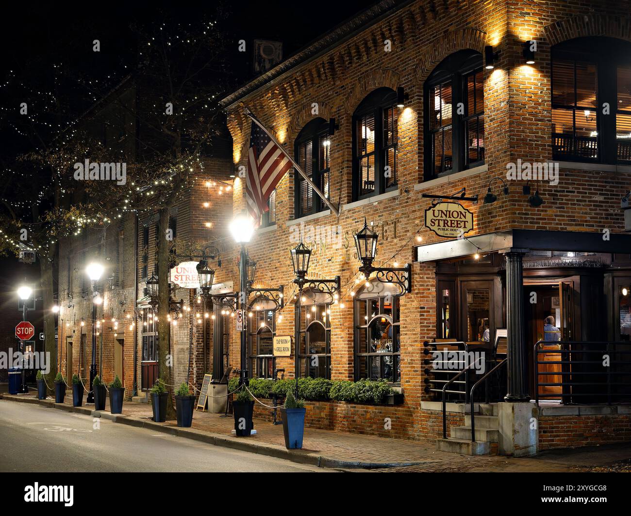 Union Street public House Restaurant Alexandria Virginie // ALEXANDRIA, Virginie — le restaurant Union Street public House illuminé la nuit dans le quartier historique de la vieille ville d'Alexandria, Virginie. Le bâtiment en briques présente une architecture coloniale traditionnelle caractéristique de cette ville portuaire historique le long du fleuve Potomac. Union Street public House est un restaurant populaire connu pour sa cuisine américaine et ses fruits de mer dans un cadre de taverne historique. Le restaurant est situé près du front de mer dans l'une des plus anciennes sections d'Alexandrie. Banque D'Images