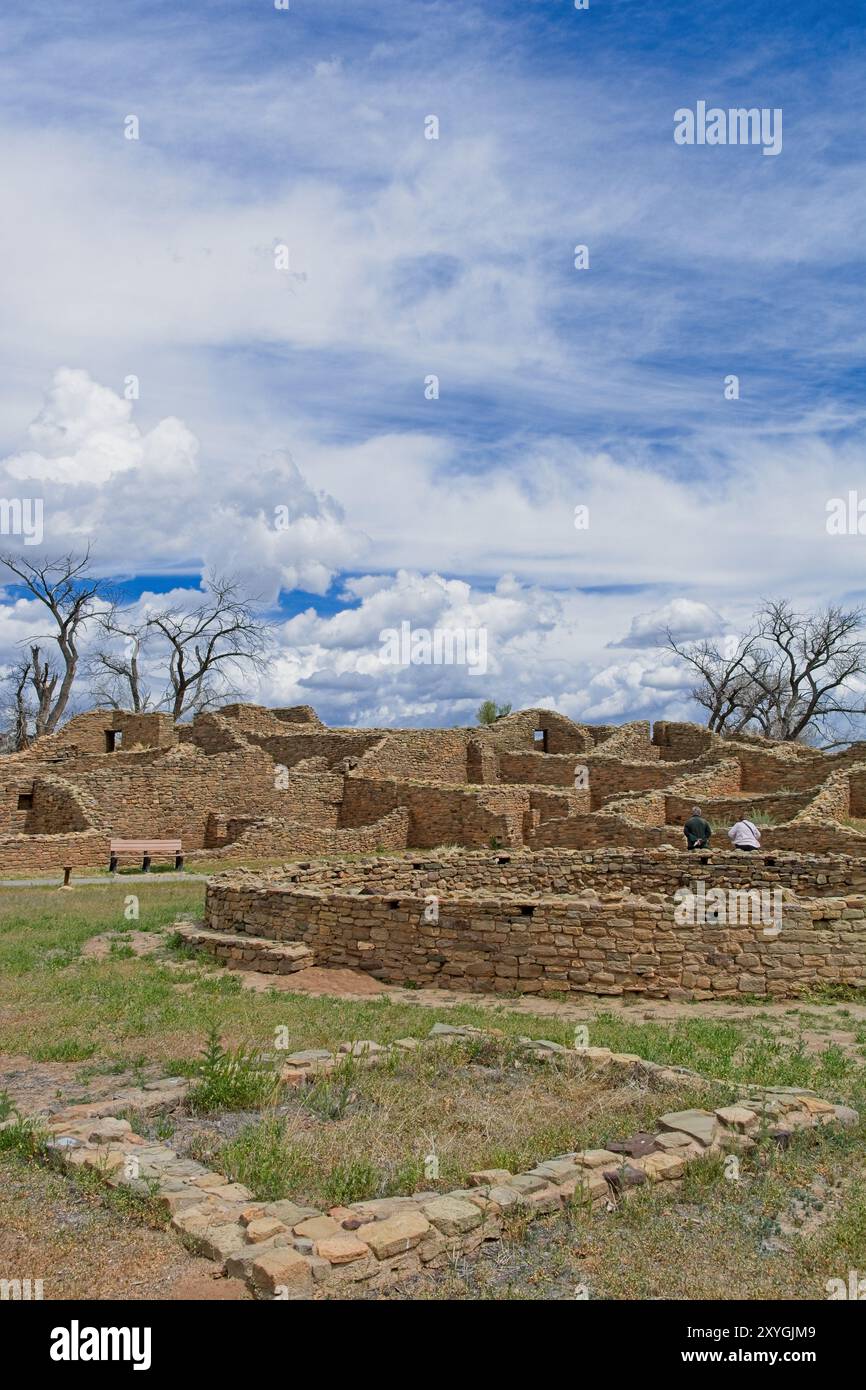 Anciens murs de maçonnerie en pierre de Puebloan et kiva circulaire sous le ciel bleu dynamique lumineux du monument national des ruines aztèques Banque D'Images