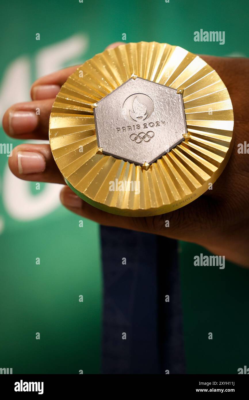 Médaille d'or des Jeux Olympiques de Paris 2024 prise de vue détaillée à la main, vainqueur d'une compétition sportive, symbole de réussite. Jeux olympiques d'été 2024 Banque D'Images