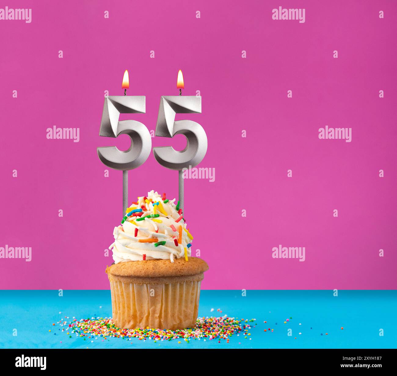 Cupcake avec bougie d'anniversaire numéro 55 - carte d'anniversaire sur fond bleu et violet Banque D'Images